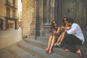 Tourists in Barcelona with guide book and a smartphone.
