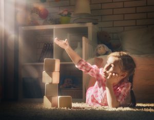 Happy child girl playing with blocks and having fun.